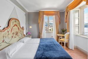 a bedroom with a large bed and a table at Hotel Cannobio in Cannobio
