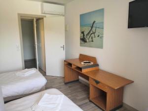 a hotel room with a desk and a bed at La Canotte in Saint-Julien-en-Born