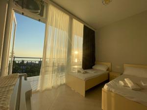una camera da letto con una grande finestra con vista sulla città di Hotel Nikolas a Gonio