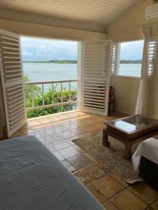 Cores do Céu Suites في بيبا: غرفة نوم بسرير وإطلالة على الماء