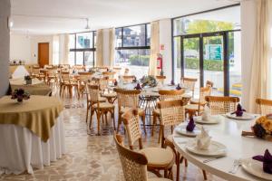 a dining room with tables and chairs and windows at Holiday Inn Queretaro Zona Diamante by IHG in Querétaro