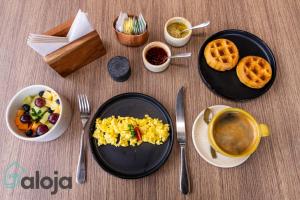 una mesa con platos de desayuno y una taza de café en Torre Sofia magnific apartments & estudios with great amenities en Cancún