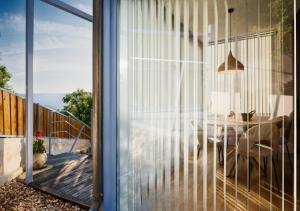 a glass door leading into a dining room with a table at O Souto da Aldea Ribeira Sacra Parada de Sil in Parada del Sil