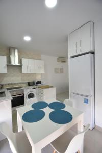 una cocina con una mesa blanca con círculos azules. en Benalroma a 50 metros de la playa! en Benalmádena