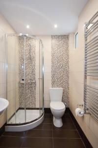 a bathroom with a toilet and a glass shower at Acropole Delphi City Hotel in Delphi