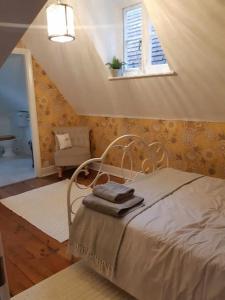een slaapkamer met een bed, een raam en een stoel bij Lovely 3 Bedroom apartment in Reigate