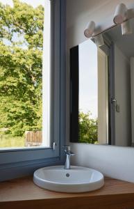 a bathroom sink with a mirror and a window at O Souto da Aldea Ribeira Sacra Parada de Sil in Parada del Sil