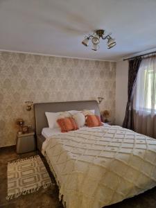 a bedroom with a large bed with orange pillows at Casa Alina in Arpaşu de Sus