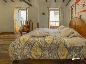 a bedroom with a bed with a colorful comforter at The Andean Rooftop guesthouse in Cusco
