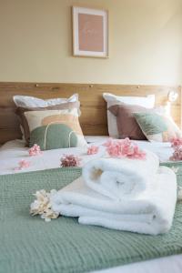 uma cama com toalhas e flores em cima em Appartement 2 chambres et balnéo proximité Dunkerque em Dunkerque