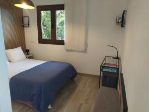 1 dormitorio con cama, mesa y ventana en 2Faros, en La Guancha