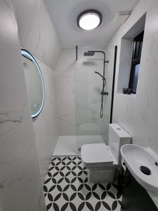 a white bathroom with a toilet and a sink at Victoria Lodgings London in London