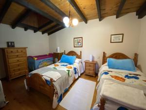 1 dormitorio con 2 camas y techo de madera en Casa Las Hortensias 2 Pendueles, en Llanes