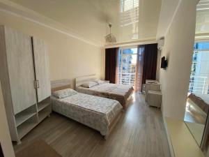 a hotel room with two beds and a window at White Room in Gonio