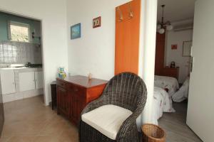 a room with a chair and a table and a bed at Apartments Cervelin in Lopud Island