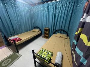 Habitación con 2 camas y cortina en Memory Lane Tioman, en Tioman Island
