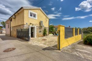 a yellow house with a fence in front of it at Casa Ti sei with Private Pool in Kaštelir