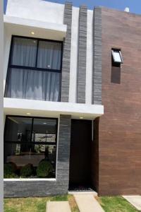 una casa con una puerta negra y una ventana en Residencia comoda, en Santa María Coronanco