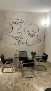 einen Tisch mit Stühlen und ein Gemälde an der Wand in der Unterkunft La casa al mare in Grottammare