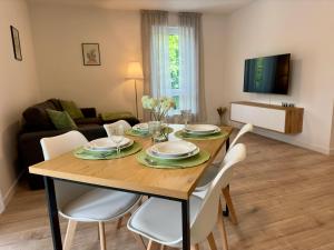a dining room with a wooden table and white chairs at Zentrale Wohnung 3 - Kostenloser Parkplatz - HDZ - Bali Therme - GOP in Bad Oeynhausen