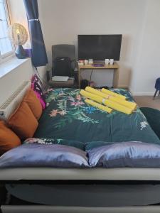 uma cama com almofadas num quarto em Chocolates&Flowers em Leverstock Green