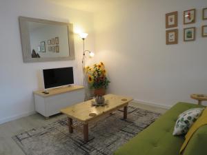 a living room with a couch and a table with a television at Quinta De Oliveiras in Beco