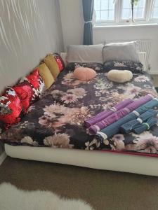 a bed with pillows on it in a bedroom at Chocolates&Flowers in Leverstock Green