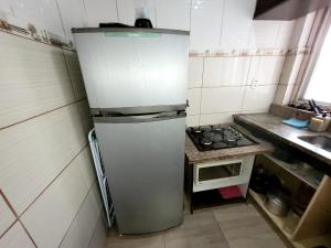 a refrigerator in a small kitchen with a stove at AP Econômico do Kilo in Cabo Frio