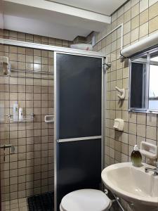 ein Bad mit einer Dusche, einem WC und einem Waschbecken in der Unterkunft AP Abdon Central Temporada in Joinville