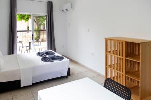 a bedroom with a bed and a cabinet and a balcony at Summer's Hotel Apartments in Ayia Napa
