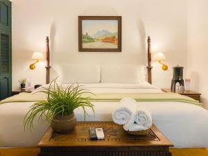 a bedroom with a bed with towels on a table at El Carmen Hotel in Antigua Guatemala