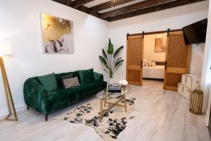 a living room with a green couch and a table at Esplanade Magic 5 Just Minutes By Uber Or Car To French Quarter and 5 mins from Superdome in New Orleans