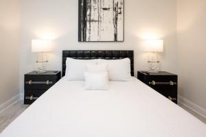 a bedroom with a large white bed with two night stands at Esplanade Magic 5 Just Minutes By Uber Or Car To French Quarter and 5 mins from Superdome in New Orleans