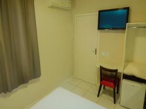 a room with a toilet and a television in it at Hotel Elevado in Porto Alegre