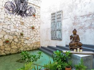 a statue of a buddha sitting next to a building at Caribbean Paradise Hotel Boutique & Spa by Paradise Hotels - 5th Av Playa del Carmen in Playa del Carmen