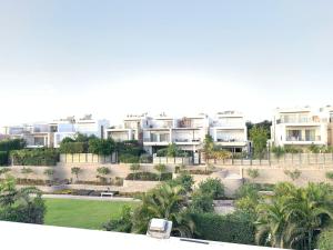 an aerial view of a resort with palm trees and houses at فيلا فندقية بحديقه داخل كمبواند ويستاون بيفرلي هيلز الشيخ زايد بسعر مميز in Sheikh Zayed