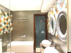 a bathroom with two sinks and a tub and a mirror at فيلا فندقية بحديقه داخل كمبواند ويستاون بيفرلي هيلز الشيخ زايد بسعر مميز in Sheikh Zayed +25 photos