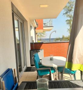 a patio with a table and chairs on a balcony at Apartament K&K Klifowa Rewal in Rewal