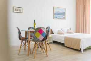 1 dormitorio con mesa, sillas y 1 cama en Villas Promis, en Čanj