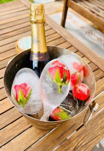 a bowl of fruit with ice and a bottle of champagne at Suite avec Jacuzzi, 15 min de Disneyland Paris - Le Nid d'Eliyah in Nanteuil-lès-Meaux