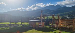 a view of a farm with mountains in the background at Good Morning Giewont & JACUZZI in Kościelisko