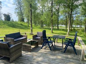 a deck with chairs and a table and chairs at Ryasjö Holiday Homes in Sexdrega