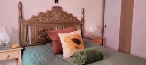 a bed with a wooden headboard and two pillows at Casa Tucho en Anaga Reserva de la Biosfera - Naturaleza-Surf-Gastronomía local-Paz y Wifi in Santa Cruz de Tenerife