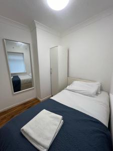 - une chambre avec un grand lit et un miroir dans l'établissement Maida Vale Urban Living, à Londres