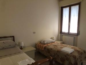 1 dormitorio con 2 camas y ventana en Il Castello en CastellʼArquato