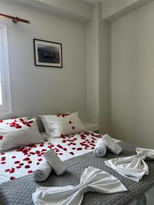 - une chambre avec un lit orné de fleurs rouges dans l'établissement Princess Sissy, à Ios Chora