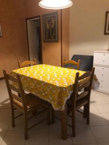 a dining room table with a yellow table cloth at Il Castello in CastellʼArquato