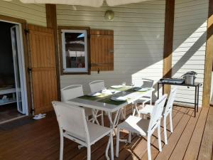 a white table and chairs on a porch with a table and chairsktop at Cottage prenium tout confort in Parentis-en-Born