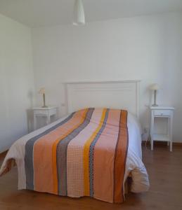 Bett in einem weißen Zimmer mit 2 Tischen in der Unterkunft Cottage prenium tout confort in Parentis-en-Born + 13 Fotos