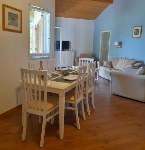 ein Esstisch und Stühle in einem Wohnzimmer in der Unterkunft Cottage prenium tout confort in Parentis-en-Born